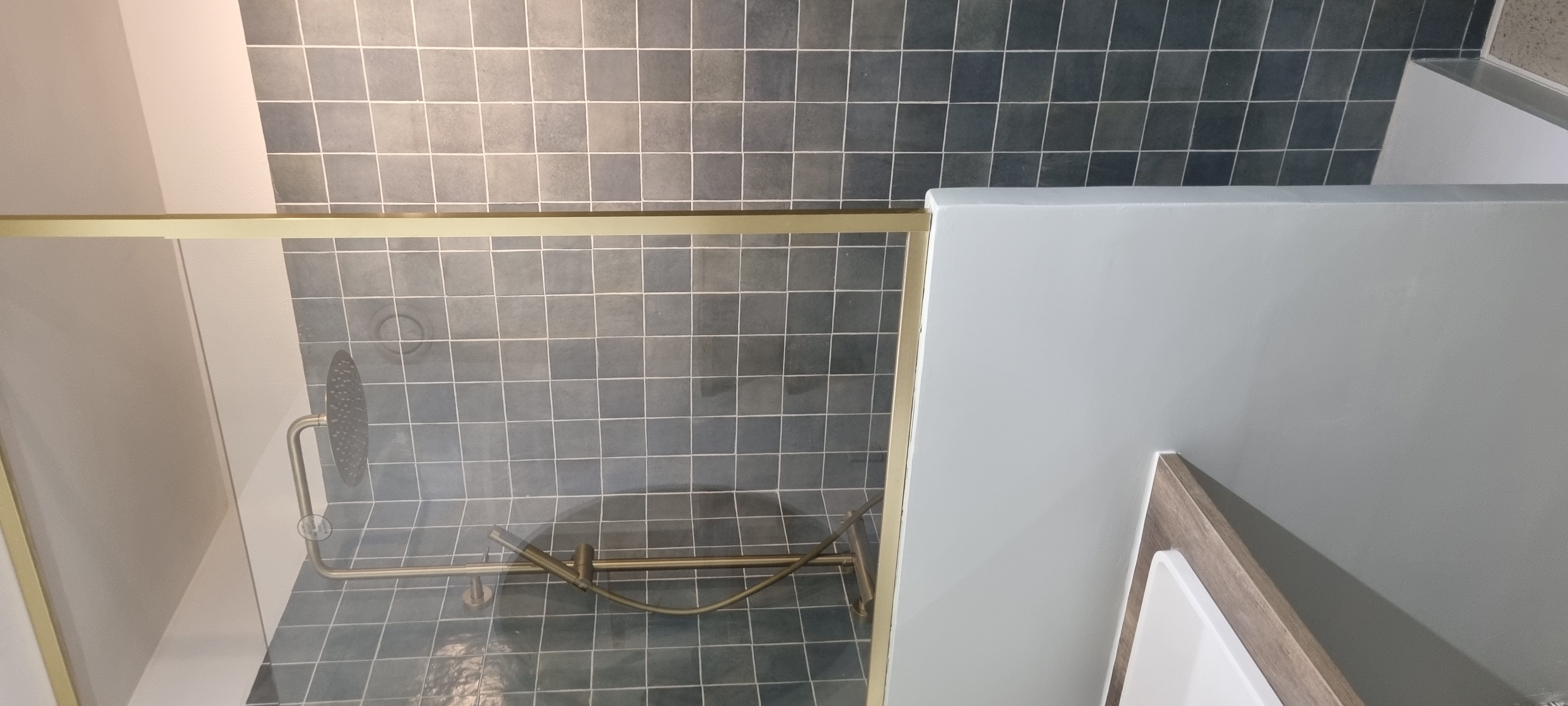 Salle de bain r&eacute;nov&eacute;e avec paroi et robinetterie moderne